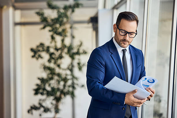 istock Professional Businessman Reviewing Documents in a Modern Corporate Office 2206511280