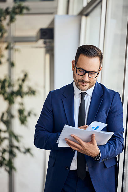 istock Confident Businessman Reviewing Documents in a Modern Office Environment 2206511284
