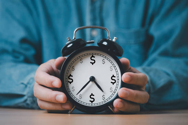 istock Businessman holding clock which USD dollar sign inside for time  is money related with active and passive income concept. 2206511352