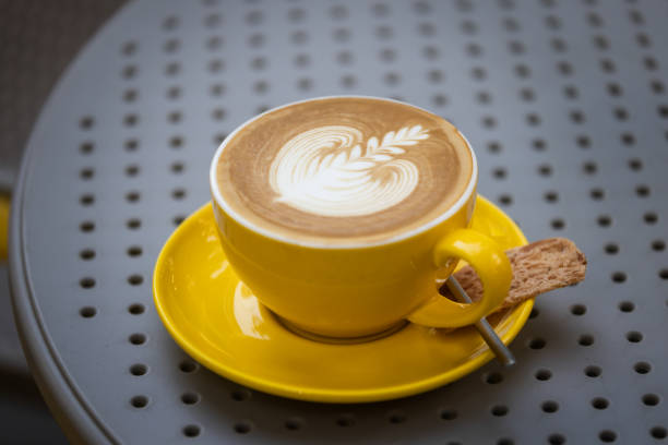 Flat white coffee is serving on the table at coffee shop.