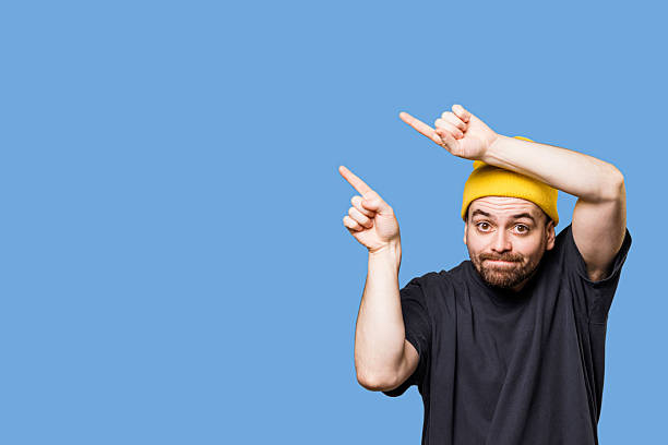 istock Man gestures upward with enthusiasm against a vibrant blue background 2206515995