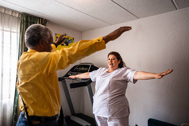 Physical therapist helping patient to do stretching exercises at home