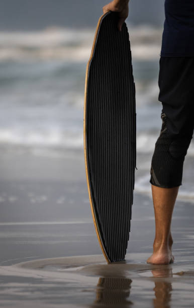 istock Unrecognizable man is holding surf board on the beach. 2206516980