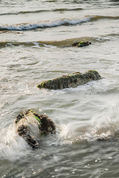 istock Rocks and basalt blocks along the North Sea coast washed over by waves. 2206517147