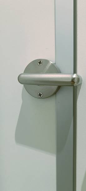 istock A modern door handle is showcased with a polished surface and minimalist design. The handle is attached to a simple white door, emphasizing functionality and style. 2206517600