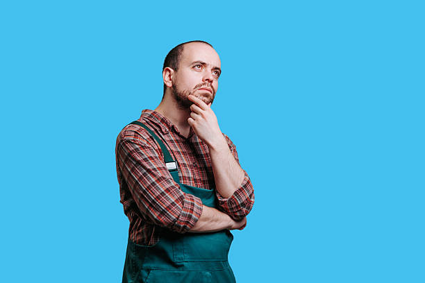 istock Man in work attire thinking thoughtfully against a blue background 2206518064