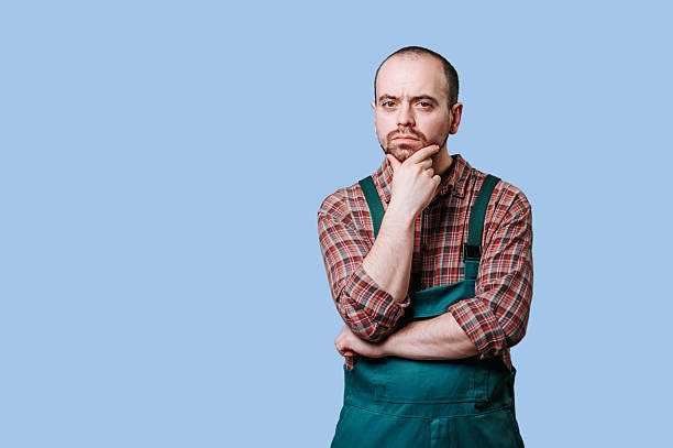 istock Thoughtful man in green apron pondering ideas in a studio setting 2206518068