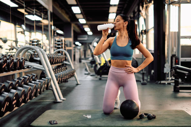istock Young athletic woman drinking protein shake after workout in gym 2206518151