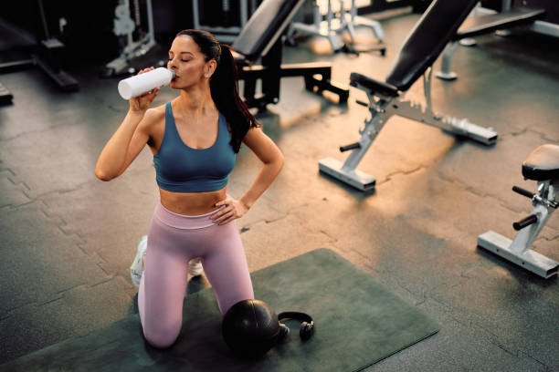 istock Young athletic woman drinking water after training in the gym 2206518155