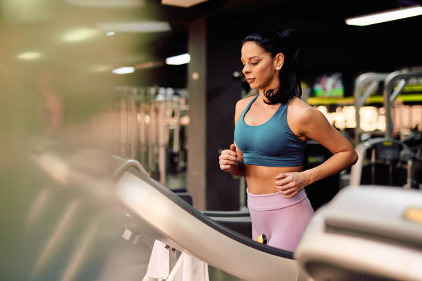 istock Determined sportswoman running on treadmill in gym doing cardio workout 2206518190