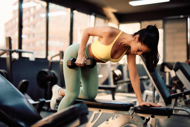 istock Determined sportswoman lifting dumbbell during workout in gym 2206518203