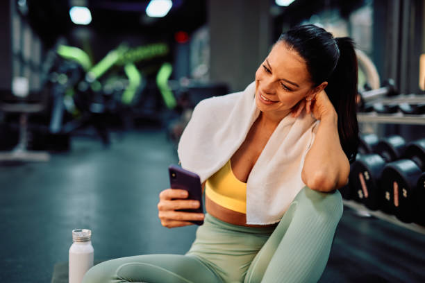 istock Smiling sportswoman using smartphone at the gym after training 2206518267