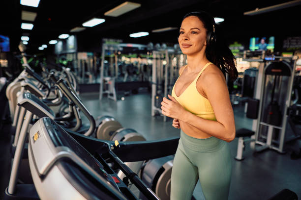 istock Young athletic woman running on treadmill in modern gym 2206518326
