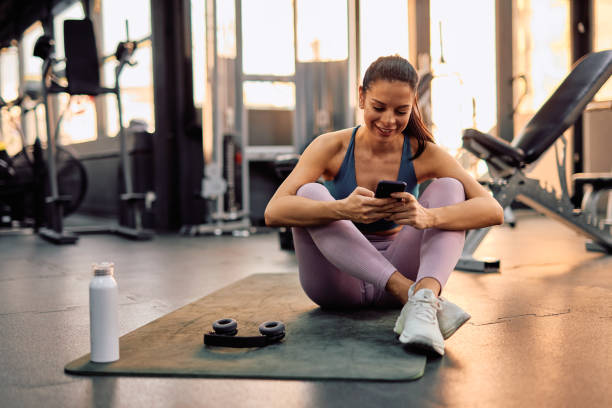istock Young athletic woman using smartphone at the gym after training 2206518378