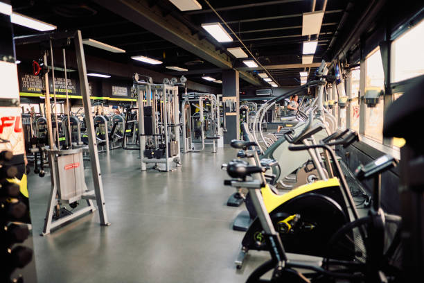 Empty gym featuring exercise bikes, treadmills, and weightlifting machines, all set and ready for fitness enthusiasts aiming to enhance their health and wellness journey