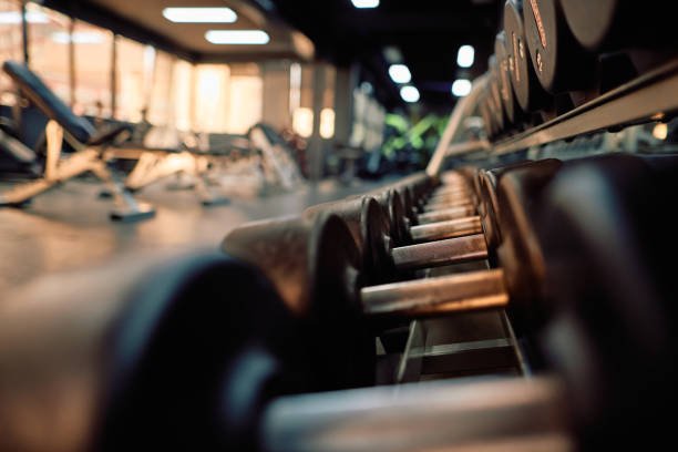 Dumbbells arranged neatly on a rack, awaiting an intense workout session in a sleek, modern fitness center, providing an inviting atmosphere for strength training and exercise
