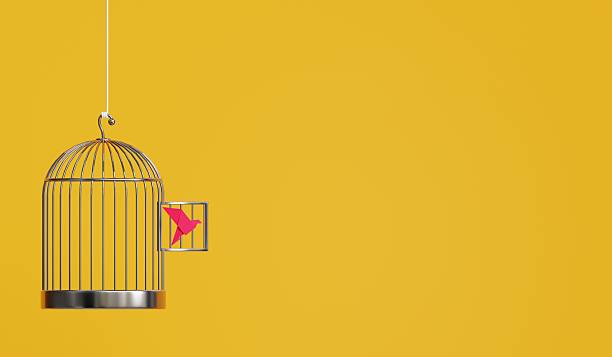 istock A pink paper bird escaping its cage against a vibrant yellow backdrop. 3D rendered creativity at its finest 2206519705