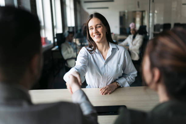 istock Smiling young woman shaking hands after successful job interview 2206520756
