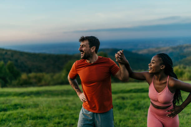 istock Interracial couple holding hands and laughing while jogging in nature 2206521245