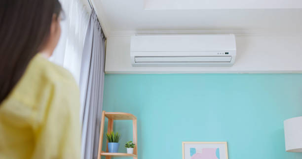 istock woman turn on air conditioner 2206522031