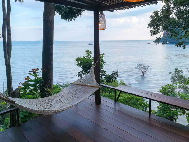 istock Hammock on a wooden deck overlooking the ocean at a tropical resort. 2206522277