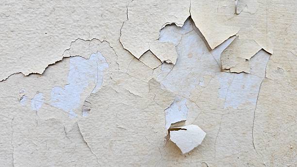istock The wall that has peeled yellow paint because it is old and weathered, needs to be repaired, repainted. Abstract background texture. 2206522830
