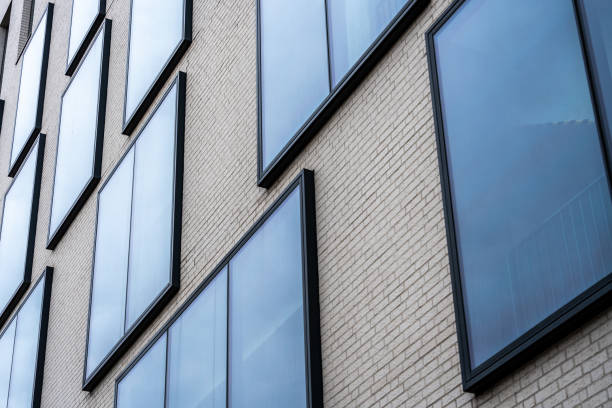 istock Glass windows protruding from beige brick building facade, modern architectural geometry 2206523053