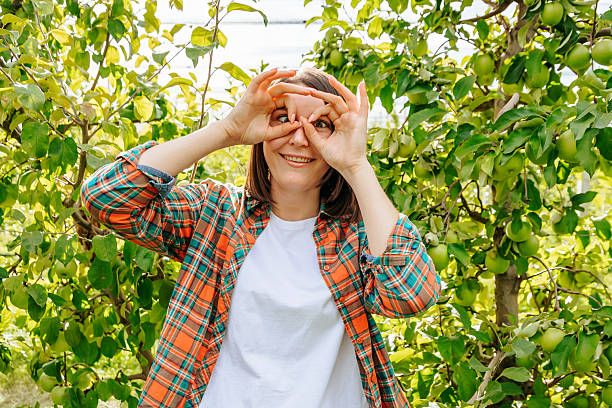 istock Woman playfully posing with hands in orchard setting during daytime 2206523513