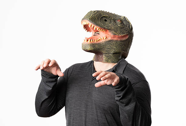 istock Man wearing a dinosaur mask roaring on white background 2206525259