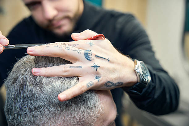istock Gray-haired man getting haircut at barber shop 2206525635