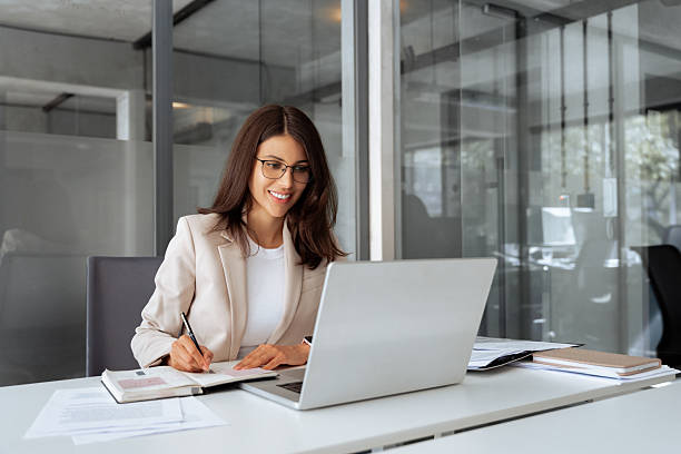 istock Middle-age latin woman using laptop computer for business studying, having videocall with online virtual webinar training meeting, writing notes. Focused businesswoman working in office. Copy space 2206527131
