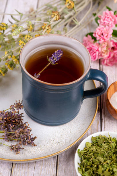 Green tea or herbal tea with cup, sugar lavender and dry herbs