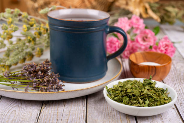 Green tea or herbal tea with cup, sugar and dry herbs