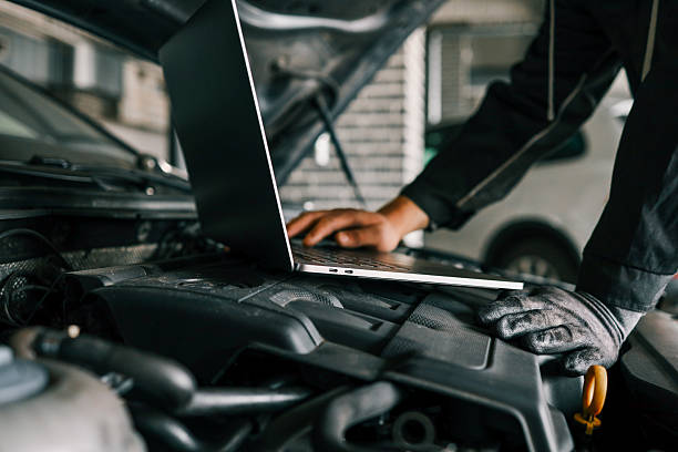 istock A mechanic using a laptop on a car engine for diagnostics in a garage. Highlights the use of technology in modern vehicle maintenance and repair 2206531358