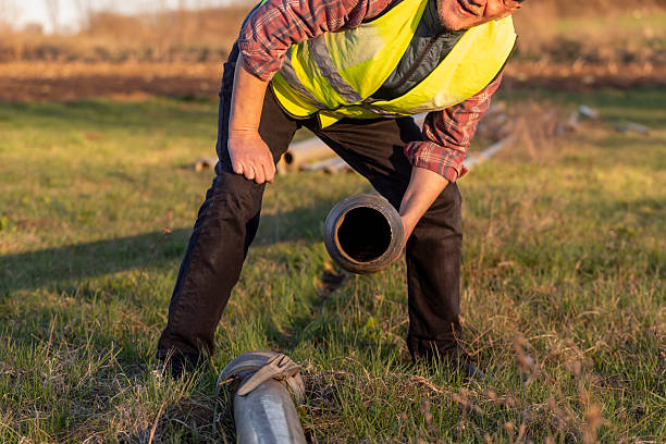 istock Worker installing irrigation pipes on agricultural field 2206532082