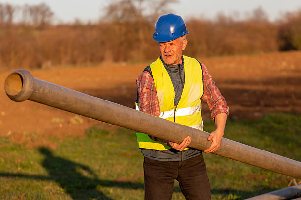 istock Worker installing irrigation pipes on agricultural field 2206532093