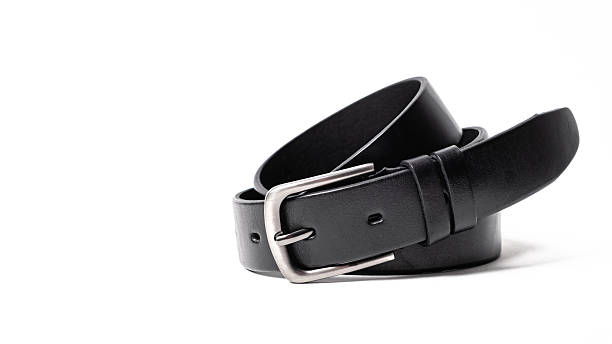 istock Twisted black leather belt with matted metal buckle isolated on white background. Fastened fashionable unisex, man or woman accessory for trousers, jeans, dress. Male luxury strap. Haberdashery goods 2206538274