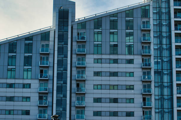 Exterior view of a modern apartment building with many windows and balconies, emphasizing geometric patterns and repetition in Manchester, UK.