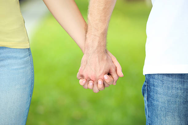 istock Young couple holding hands in the park 2206540982