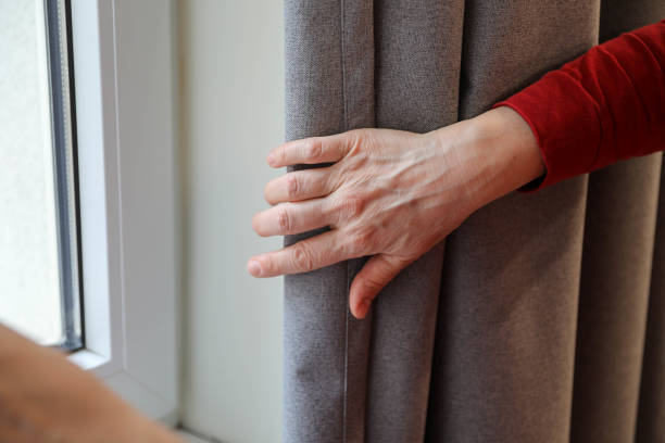 istock A woman's hand moves the curtain up close. 2206552252