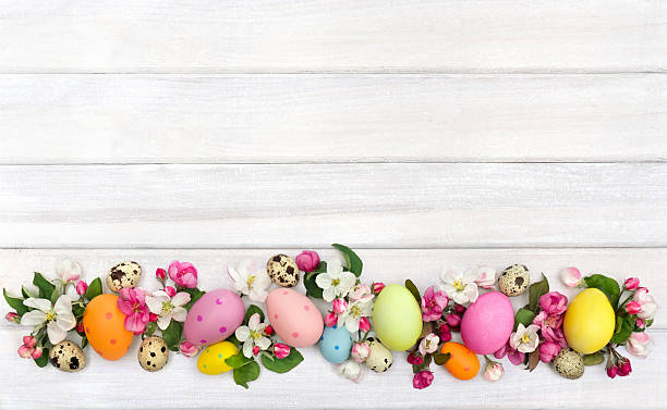 istock Easter decoration. Pink flowers apple tree and colored easter eggs and quail eggs on background of white painted wooden planks with space for text. Top view, flat lay 2206552328