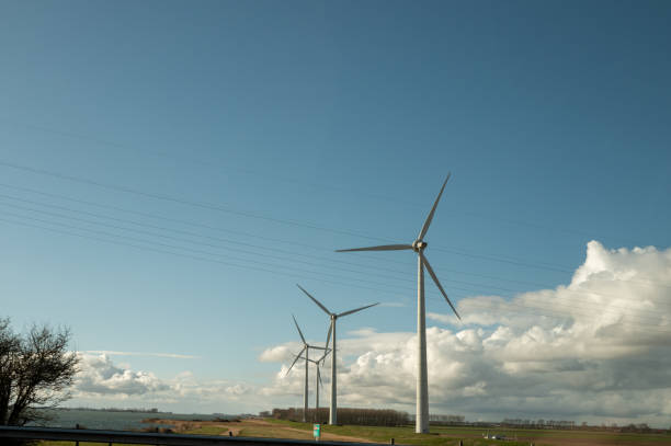 Wind turbines generating renewable energy in a field under a blue sky