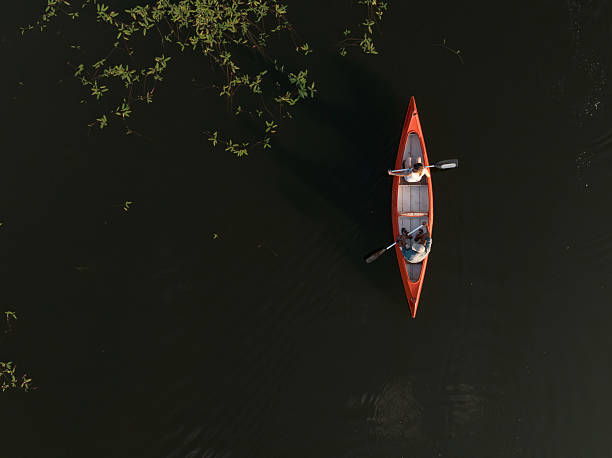 istock Couple having fun and enjoying canoeing on a summer lakeshore vacation 2206556746