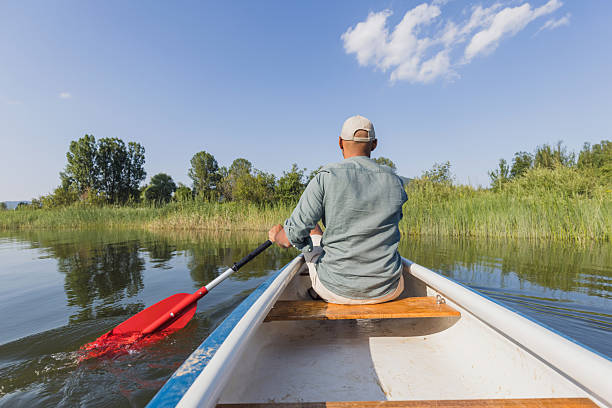 istock Man paddling a canoe during a vacation on the lake, enjoying summer sun rays 2206556902