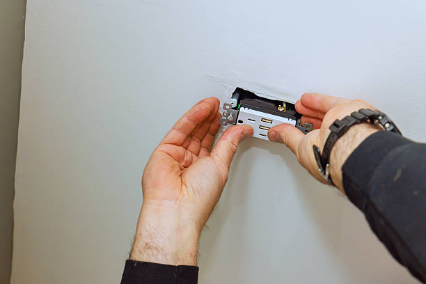 istock Electrician installing a new electrical outlet in a residential wall during daytime 2206557725