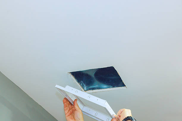 istock Worker installs new ceiling light fixture in modern room during daytime renovations 2206557739