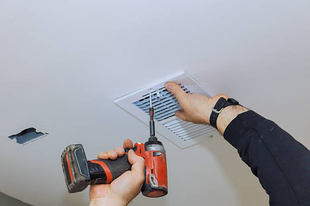 istock Homeowner repairing HVAC vent in ceiling using power drill during daytime 2206557742
