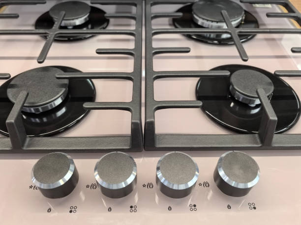 Control panel of an antique electric stove from the early 20th century. There are black knobs for turning on the burners. Background.