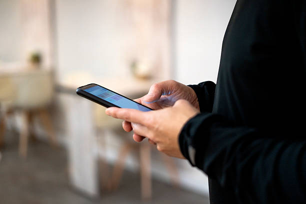 istock Businessman using smartphone app for work in office: browsing information on mobile phone 2206559908