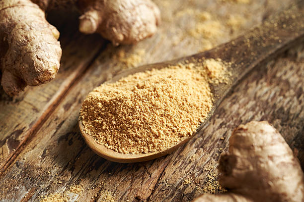 istock Ground ginger powder on a spoon with fresh ginger root 2206560388
